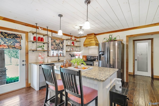 kitchen with dark hardwood / wood-style flooring, stainless steel appliances, hanging light fixtures, and premium range hood