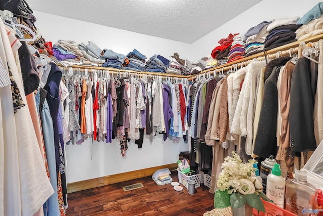 walk in closet with dark hardwood / wood-style flooring