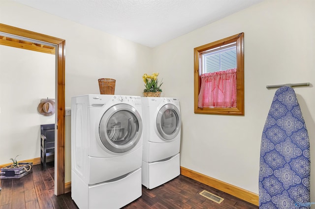 laundry area featuring a textured ceiling, dark wood-type flooring, and independent washer and dryer