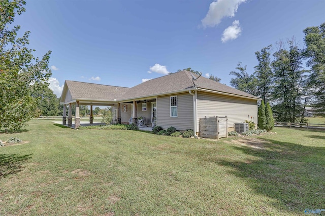 rear view of property with a yard and central AC