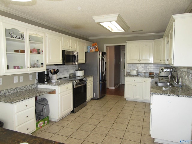 kitchen with light tile patterned floors, stainless steel appliances, a sink, and white cabinetry