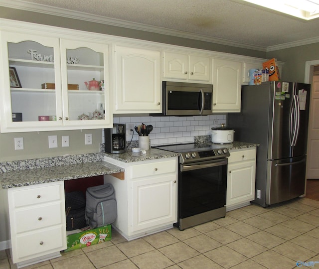 kitchen featuring tasteful backsplash, glass insert cabinets, appliances with stainless steel finishes, crown molding, and white cabinetry