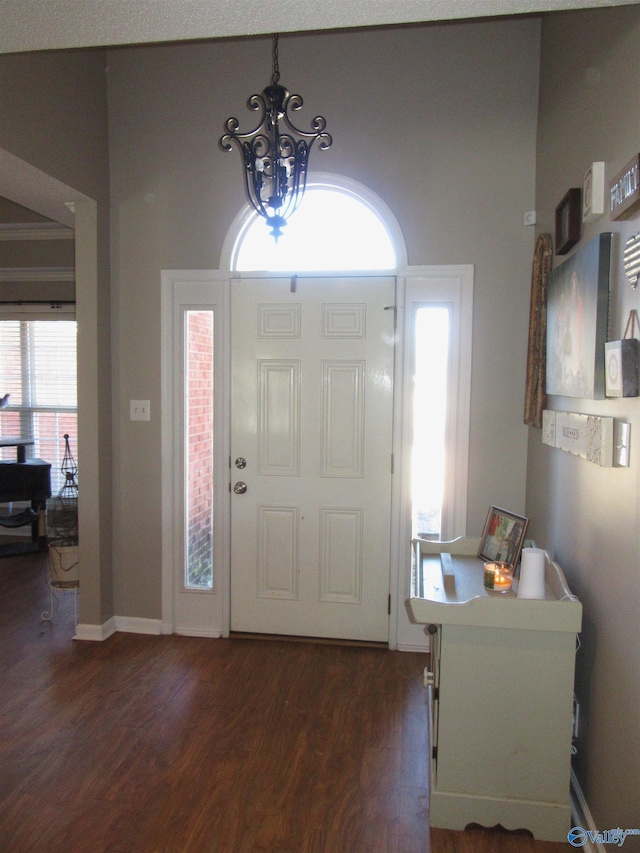 entrance foyer with dark wood-type flooring, baseboards, and an inviting chandelier