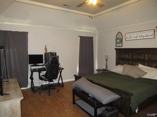 bedroom with ornamental molding, a tray ceiling, and dark wood-type flooring