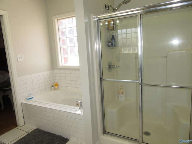 bathroom featuring tile patterned floors, a shower stall, and a bath