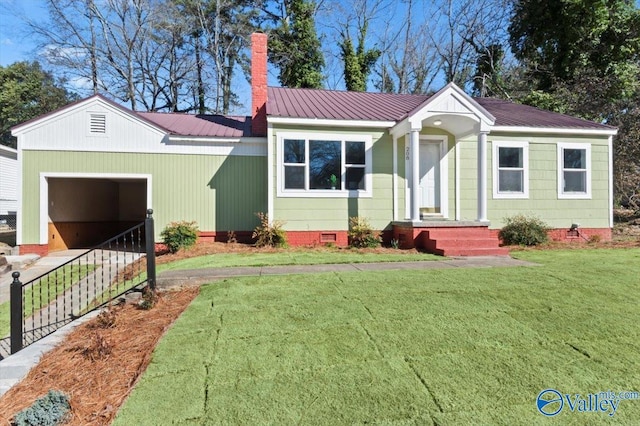 view of front of home featuring a garage, a chimney, metal roof, crawl space, and a front lawn