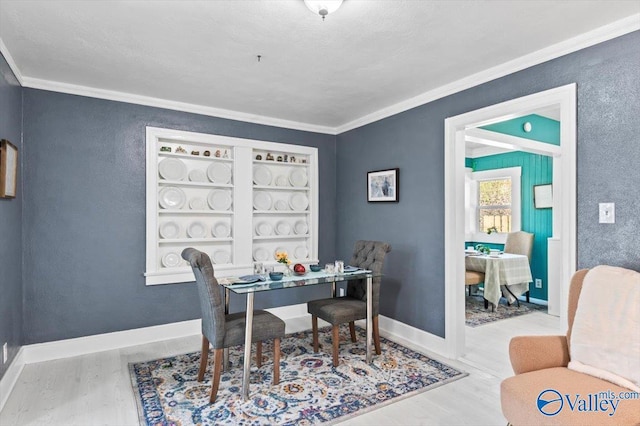 office area featuring ornamental molding, baseboards, and wood finished floors