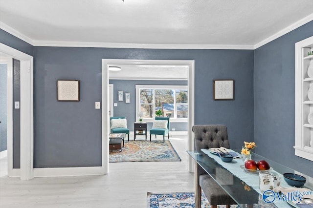 dining space featuring crown molding, baseboards, and wood finished floors