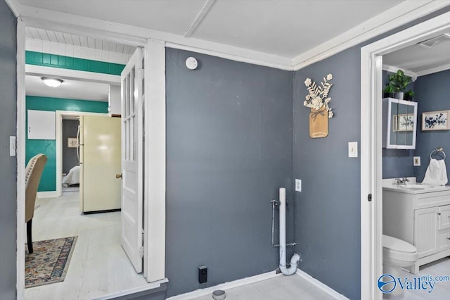 interior space with ornamental molding, a sink, visible vents, and baseboards