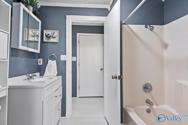 full bath with ornamental molding, tub / shower combination, vanity, and wood finished floors