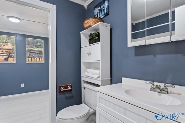 bathroom featuring baseboards, vanity, and toilet