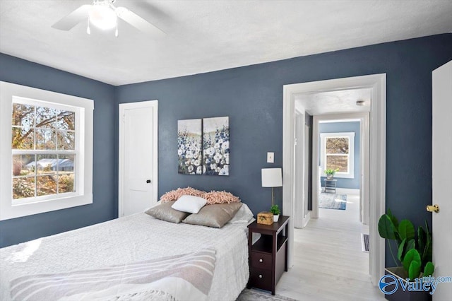 bedroom featuring a ceiling fan, visible vents, and wood finished floors