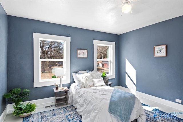 bedroom with a ceiling fan, visible vents, and baseboards