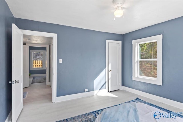 unfurnished bedroom with ceiling fan, baseboards, and wood finished floors