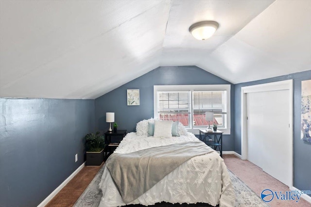 carpeted bedroom with lofted ceiling and baseboards