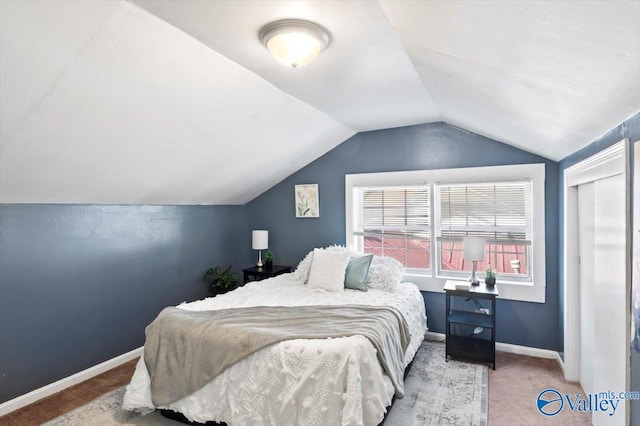 bedroom with carpet floors, lofted ceiling, and baseboards