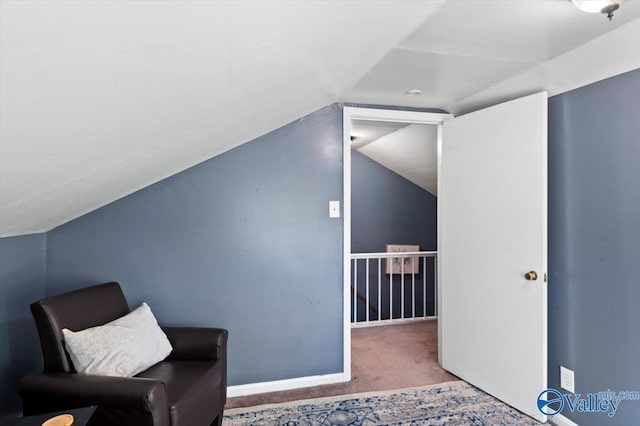 unfurnished room featuring an upstairs landing, carpet, lofted ceiling, and baseboards