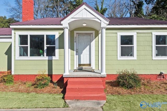 view of front facade featuring crawl space, metal roof, and a chimney