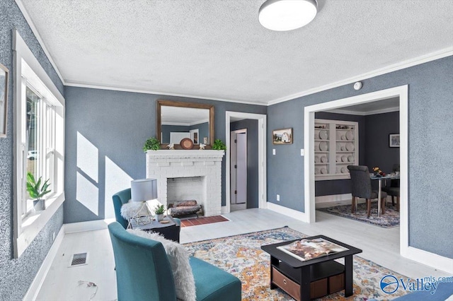 living area featuring a textured ceiling, wood finished floors, visible vents, ornamental molding, and a brick fireplace