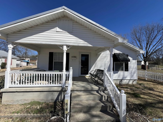 bungalow-style home with covered porch and fence