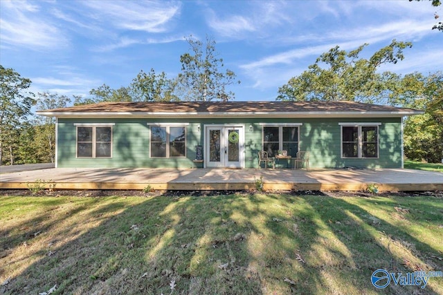 back of house with french doors, a deck, and a yard