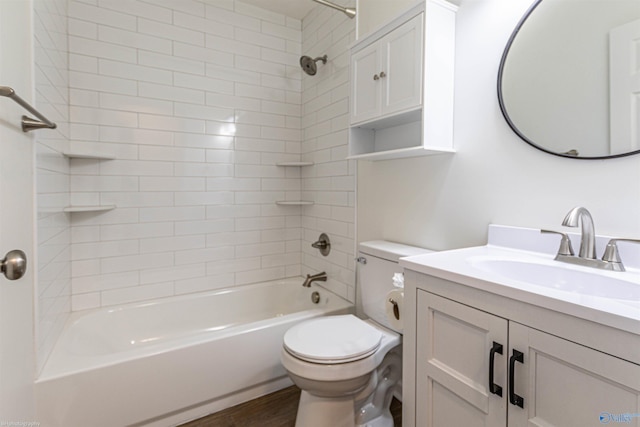 full bathroom with vanity, tiled shower / bath, hardwood / wood-style floors, and toilet