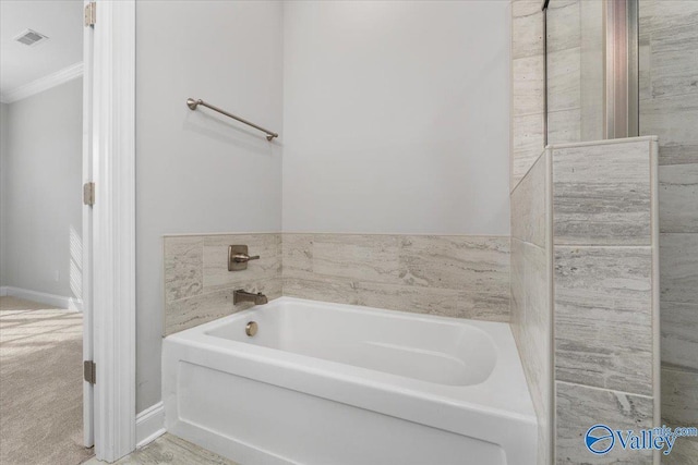 bathroom featuring ornamental molding and a bath