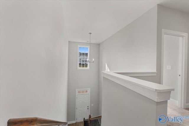 stairway with carpet and an inviting chandelier