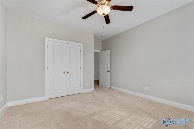 unfurnished bedroom featuring ceiling fan, light carpet, and a closet