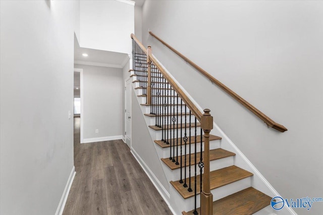 stairway featuring crown molding and wood-type flooring