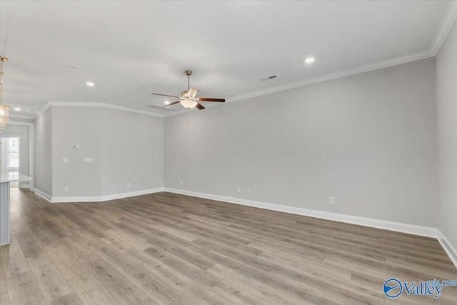 empty room with ceiling fan, ornamental molding, and light hardwood / wood-style flooring