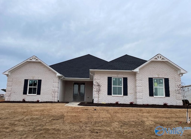 26415 Birkshire Ln, Athens, AL 35613 - view of front of house with french doors, a shingled roof, a front lawn, and brick siding