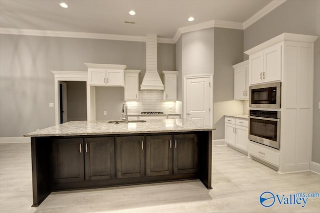 26415 Birkshire Ln, Athens, AL 35613 - kitchen featuring stainless steel appliances, a sink, custom range hood, white cabinetry, and decorative backsplash