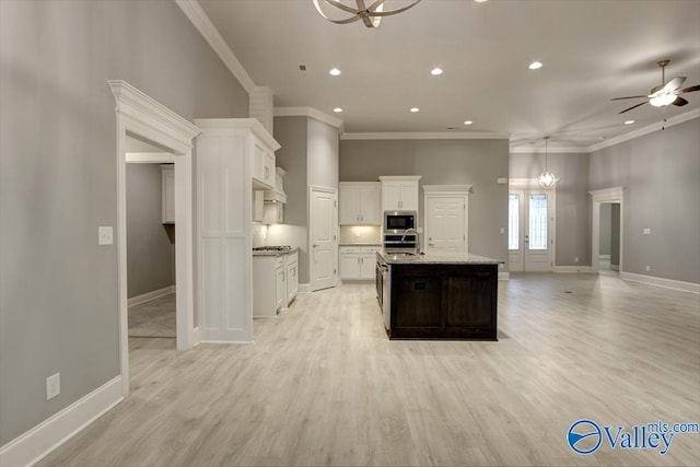 26415 Birkshire Ln, Athens, AL 35613 - kitchen with open floor plan, appliances with stainless steel finishes, an island with sink, white cabinetry, and ornamental molding