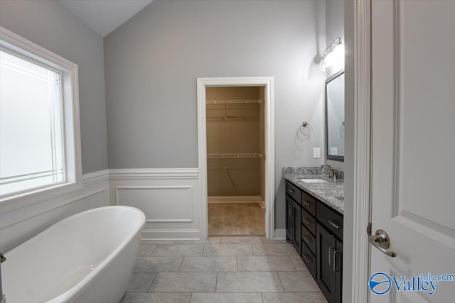 26415 Birkshire Ln, Athens, AL 35613 - bathroom with double vanity, a soaking tub, tile patterned flooring, a spacious closet, and vaulted ceiling