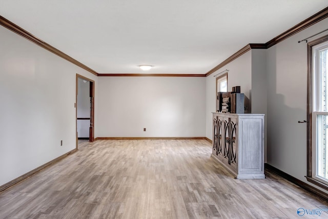 spare room featuring ornamental molding, plenty of natural light, and light wood-type flooring