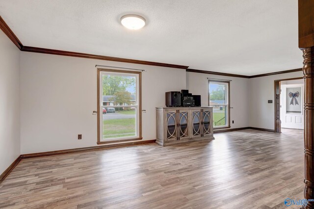 unfurnished living room with crown molding, hardwood / wood-style flooring, and a textured ceiling