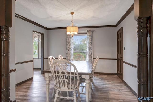 dining area featuring wood-type flooring, a textured ceiling, and plenty of natural light