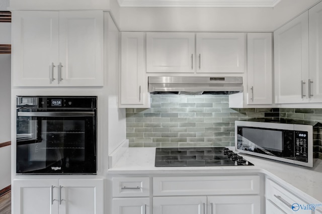 kitchen featuring black appliances, white cabinets, and backsplash