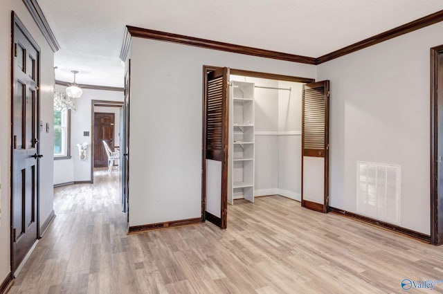 unfurnished bedroom with ornamental molding and light wood-type flooring