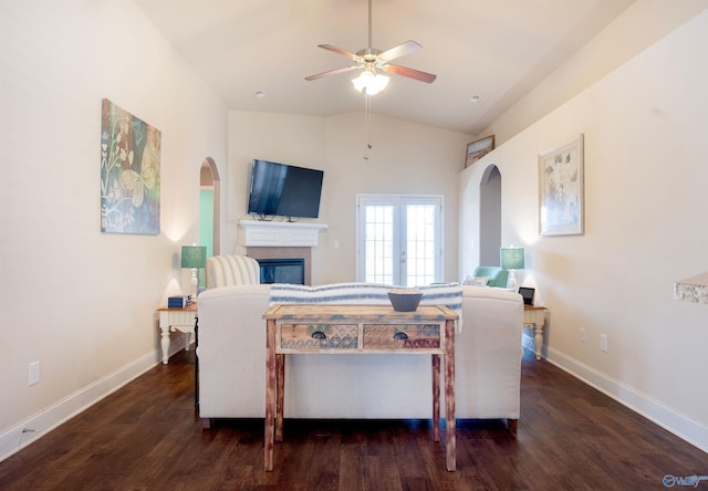 living area with vaulted ceiling, arched walkways, a ceiling fan, and wood finished floors