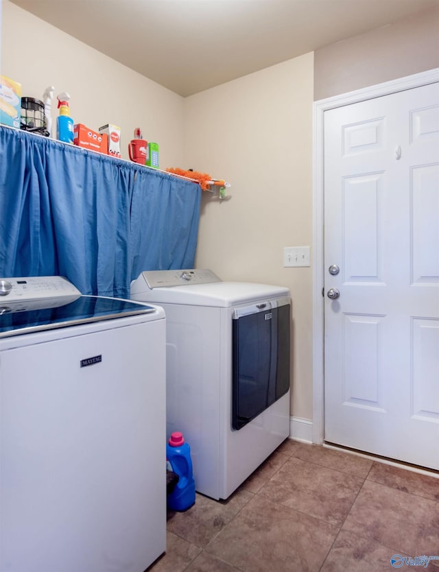 clothes washing area featuring separate washer and dryer, laundry area, and light tile patterned floors