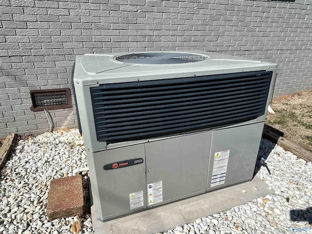 exterior details featuring brick siding and central AC unit