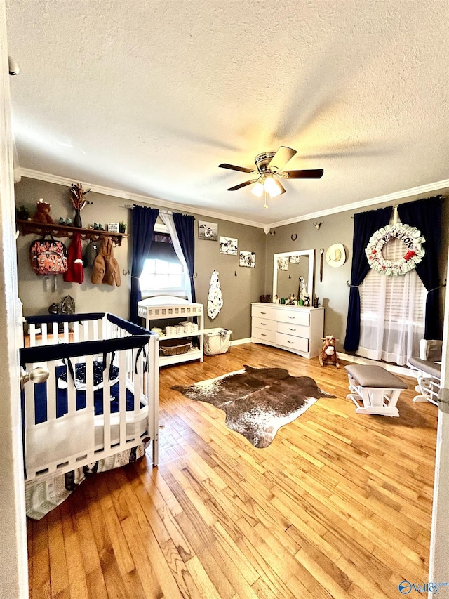 bedroom featuring a textured ceiling, wood finished floors, and crown molding