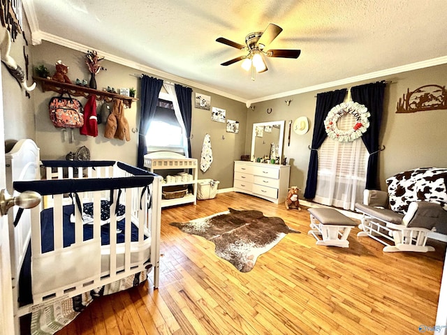 bedroom featuring a textured ceiling, ornamental molding, and wood finished floors