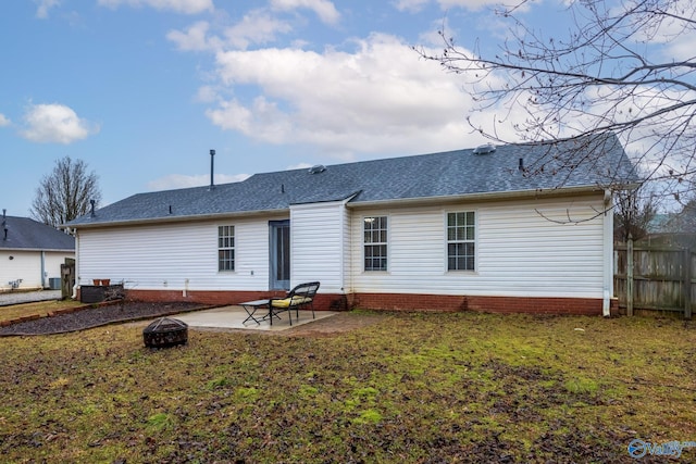 back of property with a patio area, a lawn, and an outdoor fire pit