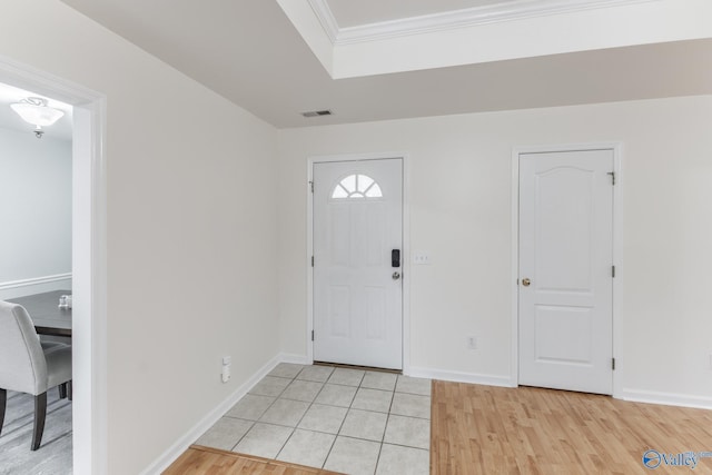 entrance foyer with ornamental molding and light wood-type flooring