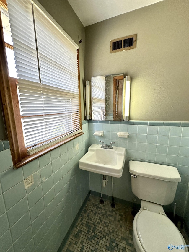 bathroom with visible vents, toilet, tile walls, wainscoting, and tile patterned flooring