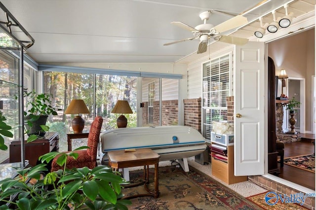 sunroom with ceiling fan and lofted ceiling