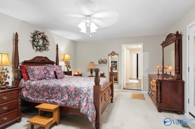 carpeted bedroom with ceiling fan and a textured ceiling